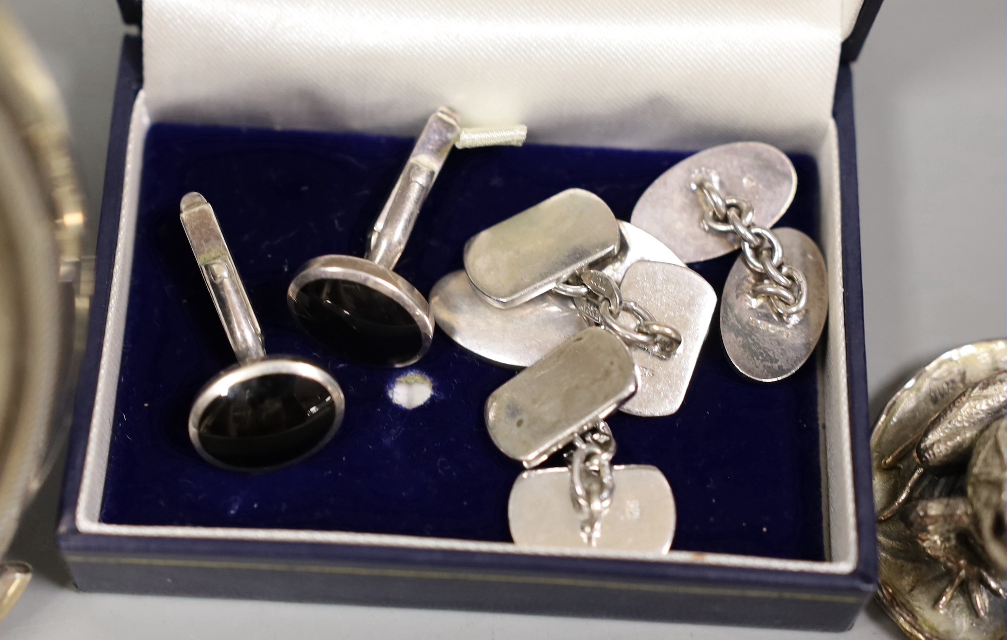 A pair of silver and black enamel cufflinks, two pairs of white metal cufflinks, a small silver overlaid frog paperweight and a photograph frame, 12cm